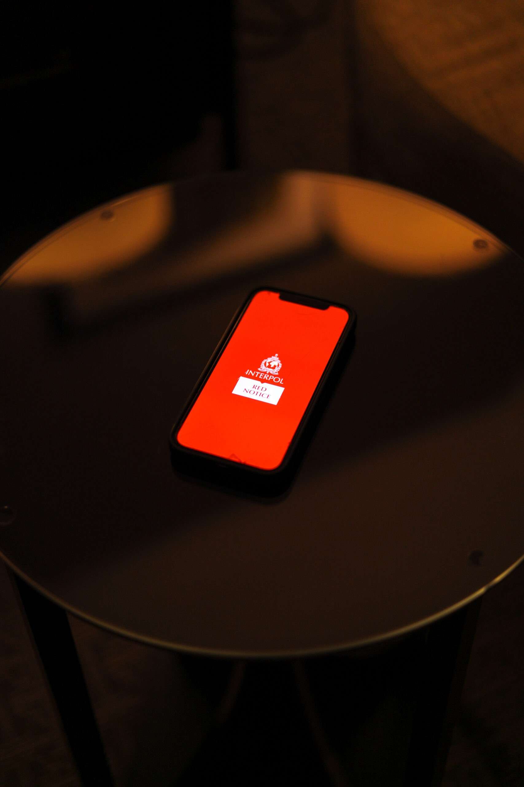 Smartphone displaying an INTERPOL Red Notice screen on a table