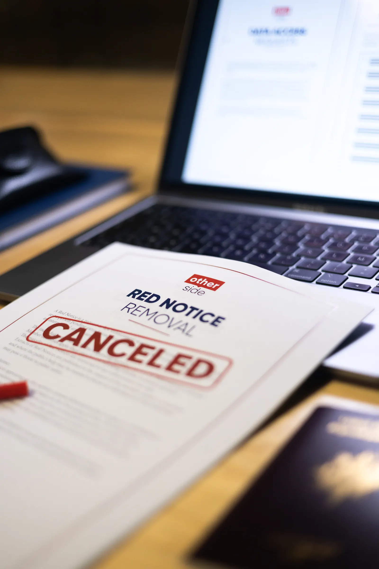 Red Notice Removal file stamped CANCELED next to a laptop, Otherside INTERPOL law firm